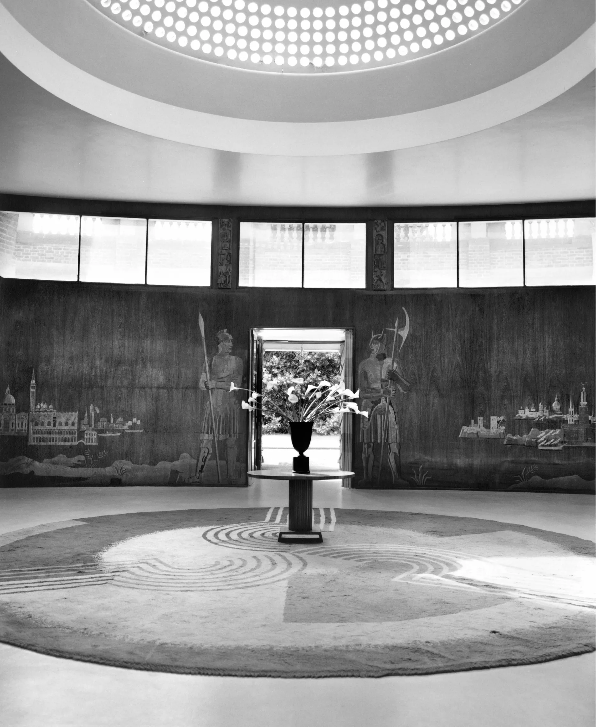 Espacio circular en blanco y negro con luz filtrada por una cubierta perforada